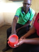 Health worker shows dirty water at health centre in Uganda